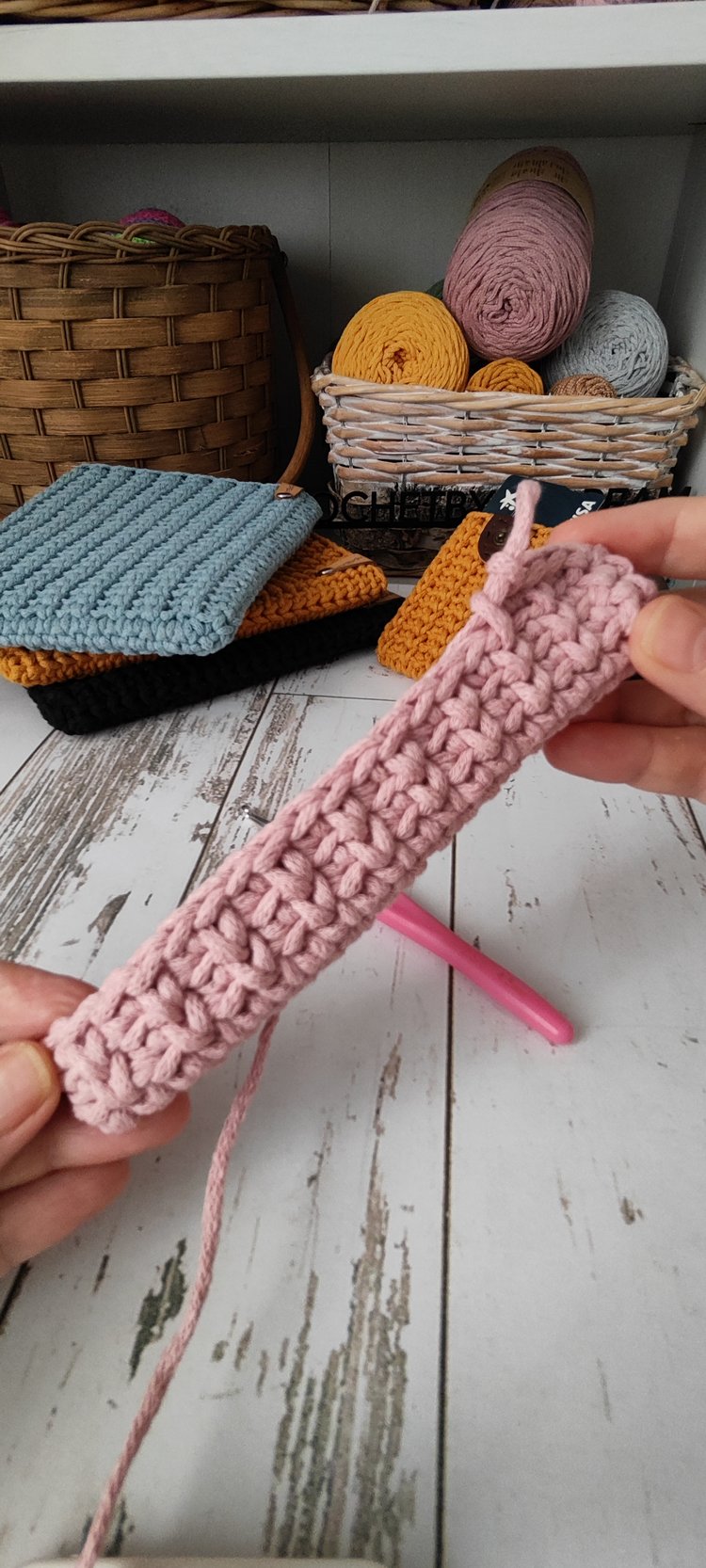 Dusty rose coloured crossbody bag in cotton rope yarn, simple leather tag branding ‘AnDREAM Crochet’ visible, elegant accessory