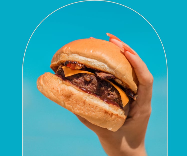 Woman's hand holding a burger