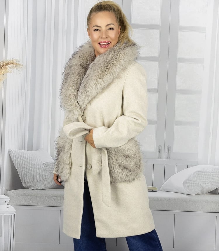 Eleganter Mantel mit Fellbesatz in Cremefarbe, abgebildet an einem Model in einem hellen Raum.