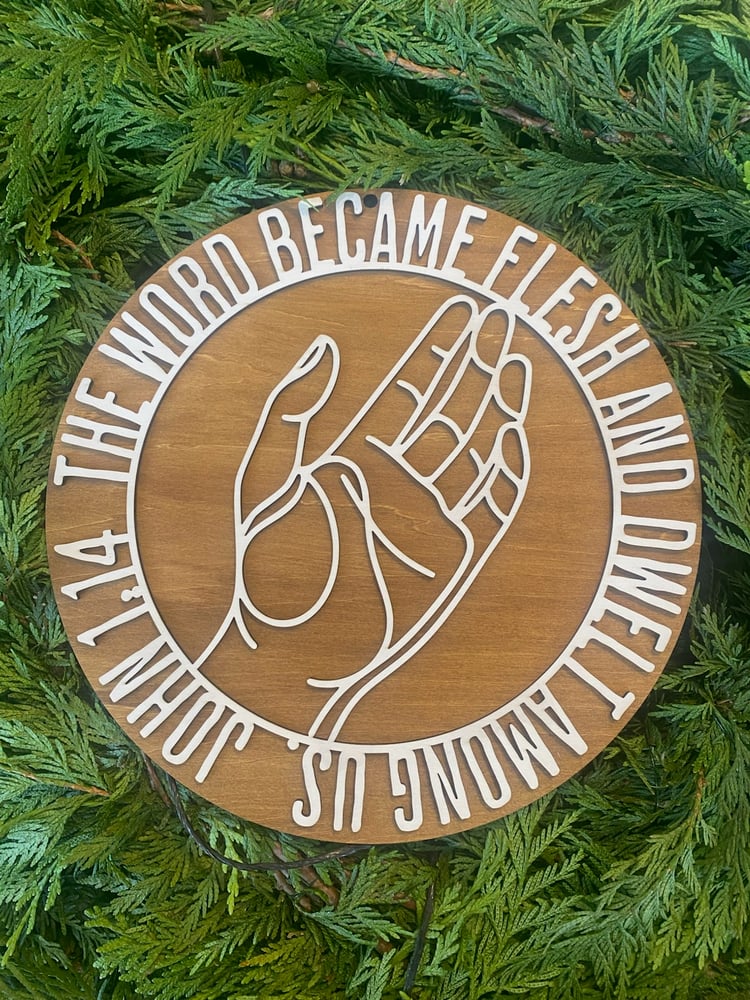 Laser cut wooden sign with Bible verse The Word Became Flesh and Dwelt Among Us.