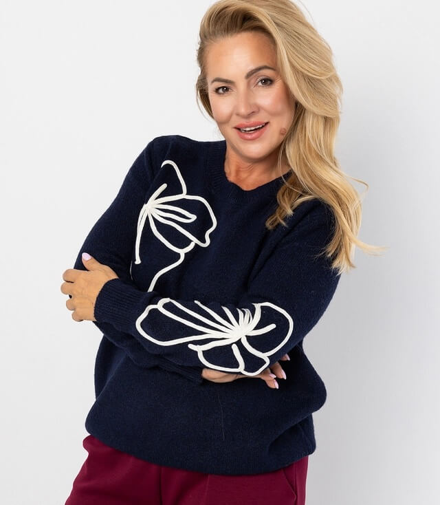 Dunkelblauer Pullover mit stylischen weißen Schleifen-Details an den Ärmeln, schick und gemütlich.