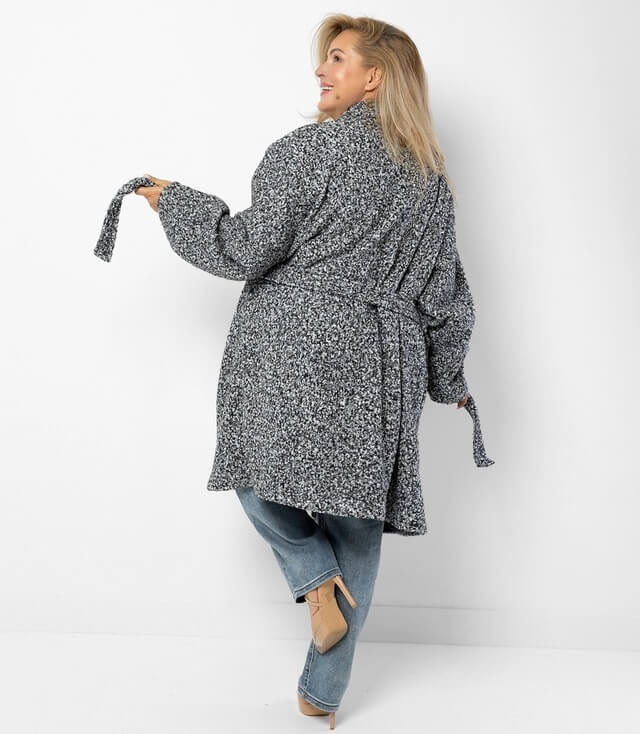 Detailansicht des grau melierten Boucle Mantels mit Knöpfen und einem Gürtel.