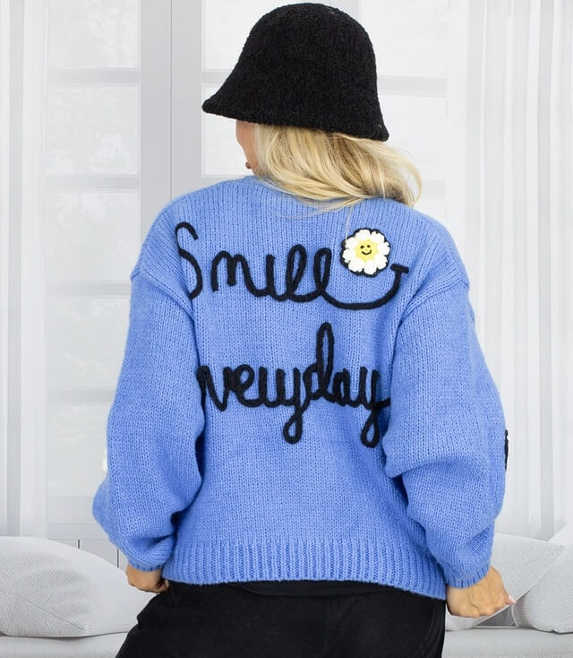 Blaue Strickjacke mit Aufschrift "Smile everyday" und Blumenmotiv auf der Rückseite.