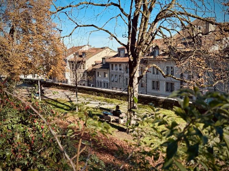A woman sat on a bench in a park in Geneva Old Town, Switzerland