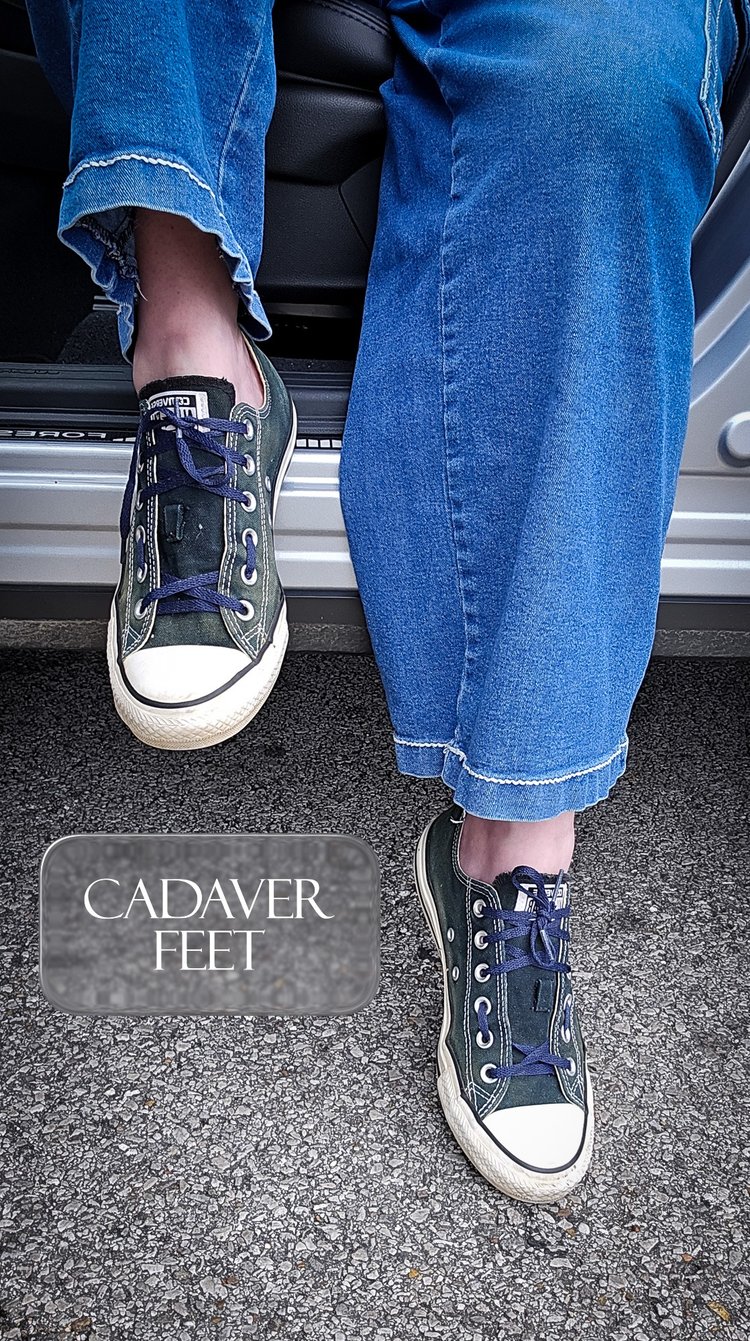 a person in loose blue jeans and faded converse exiting a vehicle