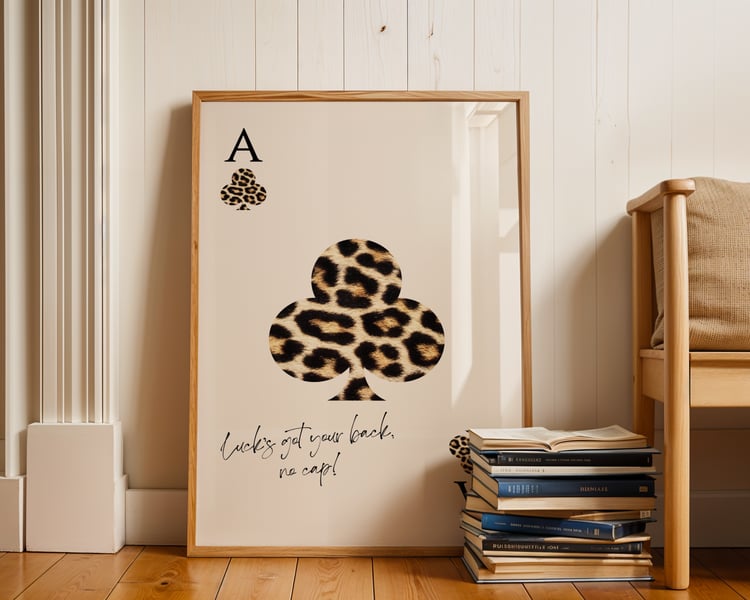 Leopard print playing card wall art poster with quote typography, framed minimalist artwork styled in a modern interior.