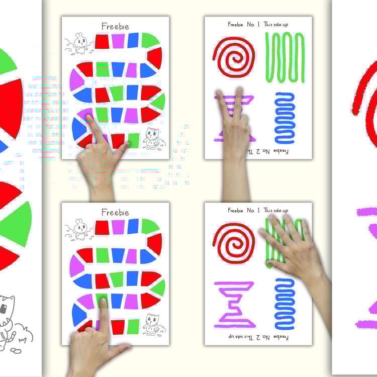 Close-up of free Hand Pop Adventure worksheets showing children's hands mimicking symbols and following colored paths for fine motor skill practice.
