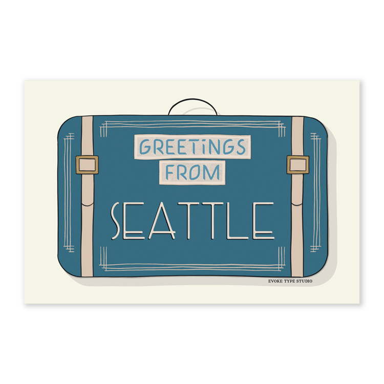 A postcard of a vintage style suitcase with the words “Greetings from Seattle” drawn in unique lettering styles. Artwork has a blue and beige color scheme