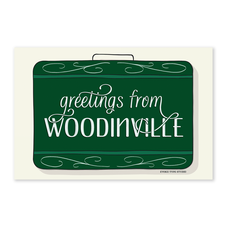 A postcard of a vintage style suitcase with the words “Greetings from Woodinville” drawn in unique lettering styles. Artwork has a green and white color scheme
