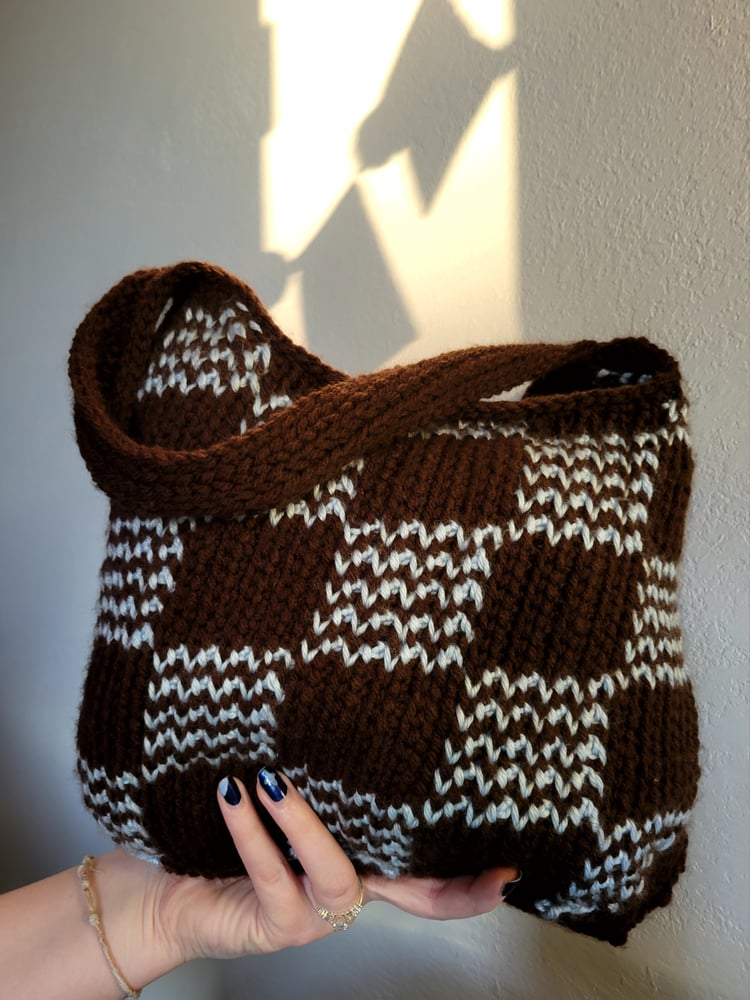 A brown an blue handbag in a check pattern