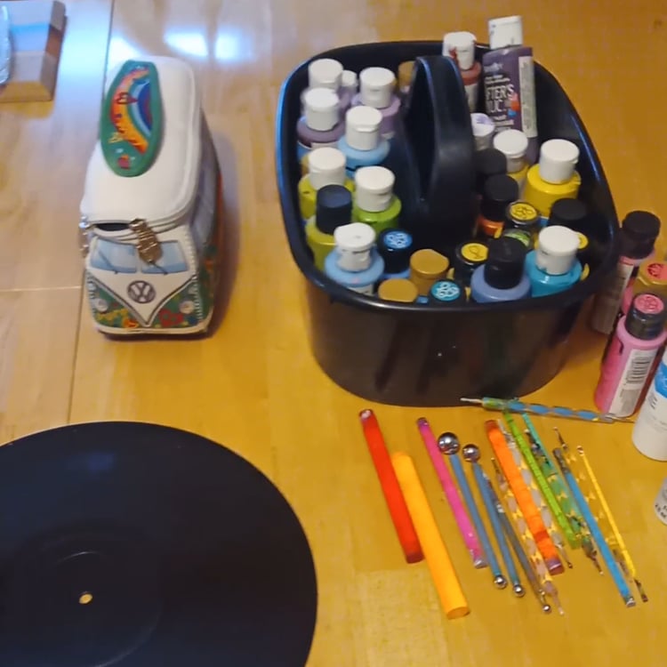 Mandala art supplies laid out on a table for a new project, including a carrying caddy with colorful paint bottles and dotting tools, perfect for creating intricate mandala designs, painting, and dot art. Narnation creative studio setup.