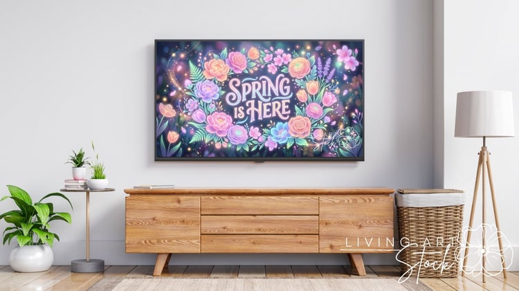 Colorful floral illustration features the phrase "Spring is Here" surrounded by a vibrant arrangement of various flowers, including roses, peonies, and tulips. The flowers are depicted in a swirling pattern with hues of pink, orange, blue, and purple. Lea