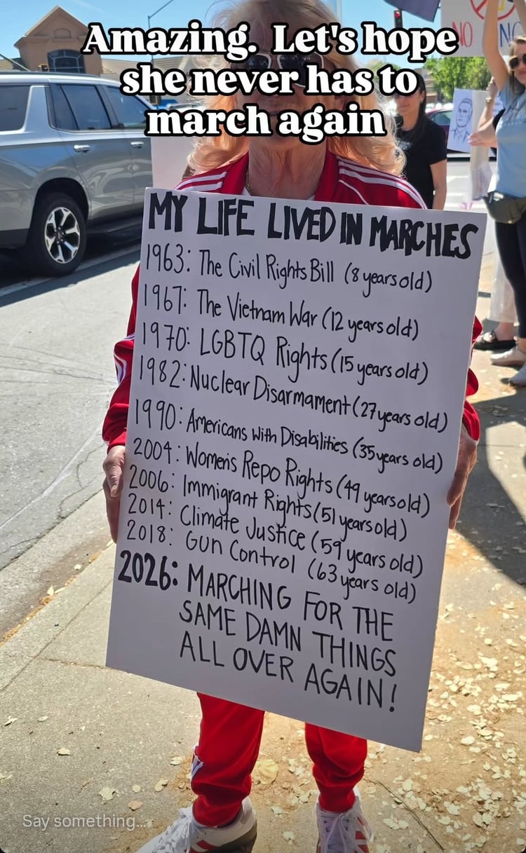 a woman holding a sign showing how her life lived in marches
