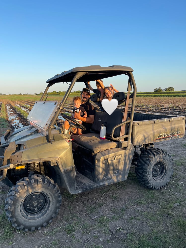 Cane farming family riding in a buggy on a sugarcane farm.