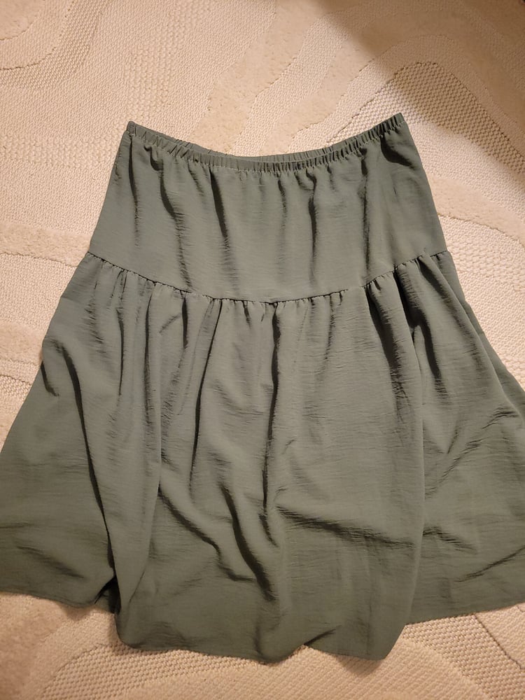 A green two-tiered skirt with an elastic waistband