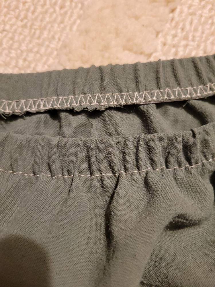 The inside and outside stitching is visible a green skirt's eslastic waistband