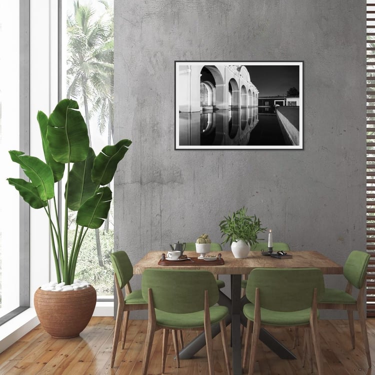 A large horizontal black and white architectural canvas print hangs on a dark charcoal dining room wall above a modern wooden table and white chairs.