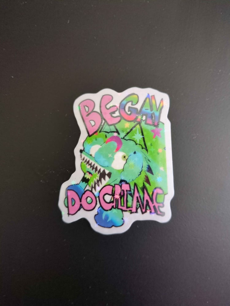 Green Sparkle COyote girl head in green sparkles covered in stars and moons blue green gradient with pink text that reads "Be Gay Do Grime" Gay text is rainbor. Wide mouth, braids and eyes looking the wrong directions.