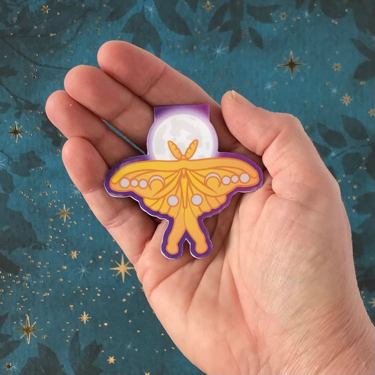 The luna moth and moon magnetic bookmark shown in-hand to demonstrate actual size.
