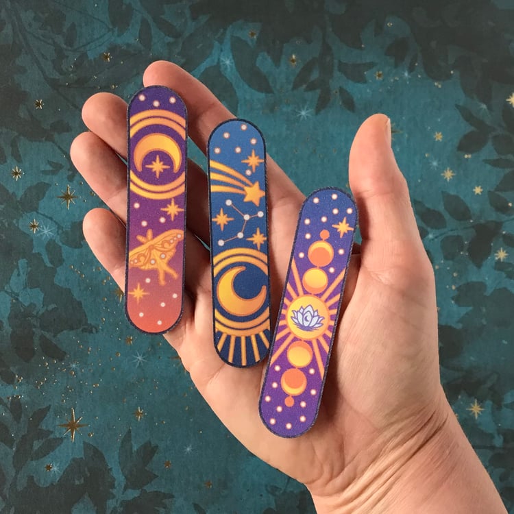 The three celestial decals in the set being shown in-hand for scale.