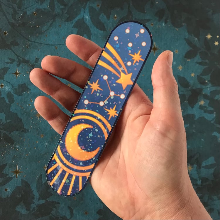 A large blue decal featuring stars and moon shown in-hand for scale.