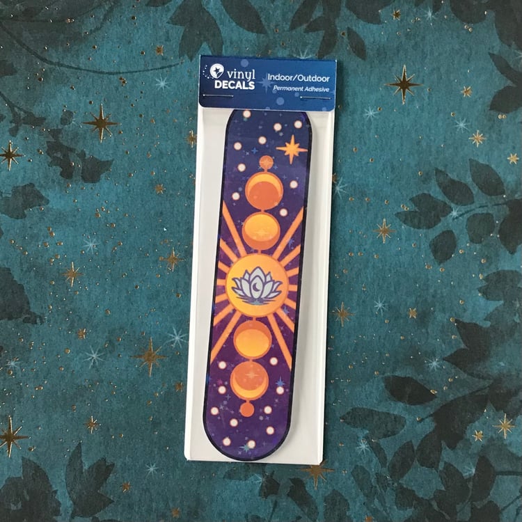 A large, celestial themed decal with lotus and moon phases plus starry laminate finish shown in its packaging.