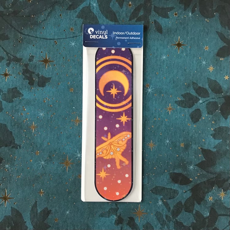 A luna moth and moon and stars-themed decal in its packaging.