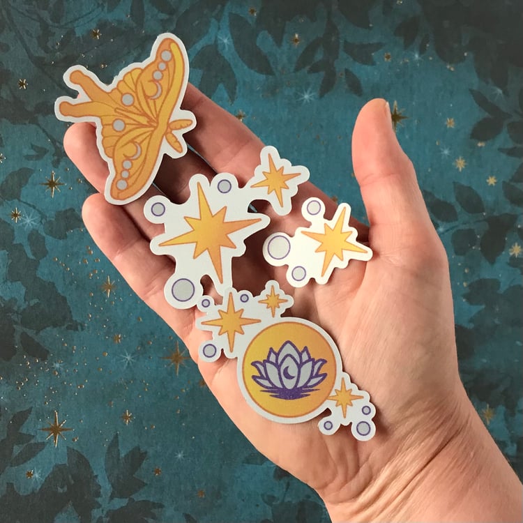Four mini, celestial-themed decals (luna moth, stars, lotus and moon) shown in-hand for scale.