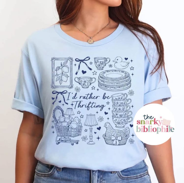 light blue unisex t-shirt with dark blue ink. Designs on collage include tea cups, lamps, chickens, vintage dishwater and stamps.
