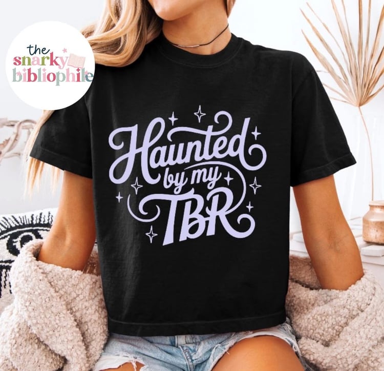 black shirt with lavender writing that says haunted by my tbr