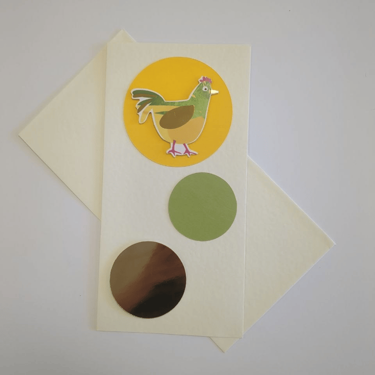 A tall portrait card in cream with a matching cream envelope. Three circles in different colours and sizes bubble up the card. The bottom one is medium and made of gold mirror card. The middle one is smaller and green. The top one is yellow and contains a