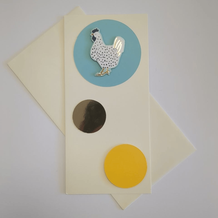 A tall portrait card in cream with a matching cream envelope. Three circles of different colours and sizes bubble up the card. The bottom one is yellow and medium. The middle one is made of gold mirror card and smaller. The top one is turquoise blue and h