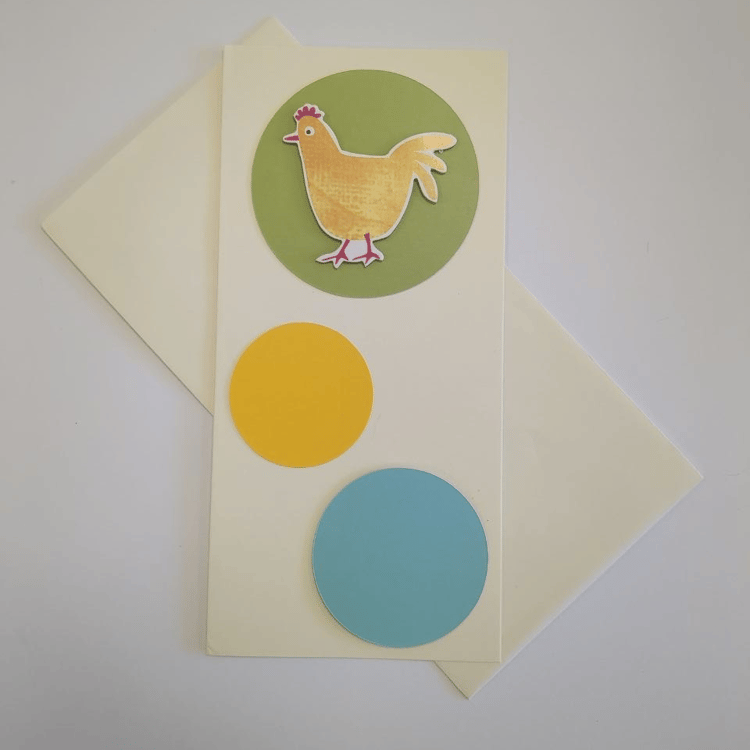A tall portrait card in cream with a matching cream envelope. Three circles in different colours and sizes bubble up the card. The bottom one is turquoise blue and medium. The middle one is smaller and yellow. The top circle is green and contains a motif 