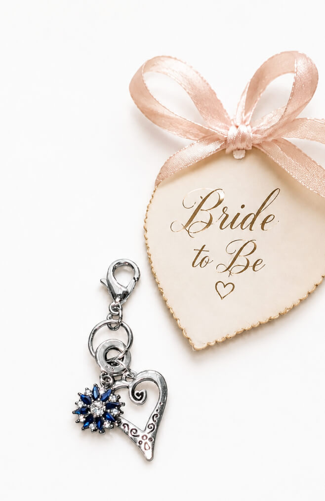 Handmade 925 sterling silver bridal bouquet memory charm featuring a sapphire blue crystal sunburst cluster inside an open filigree silver heart pendant
