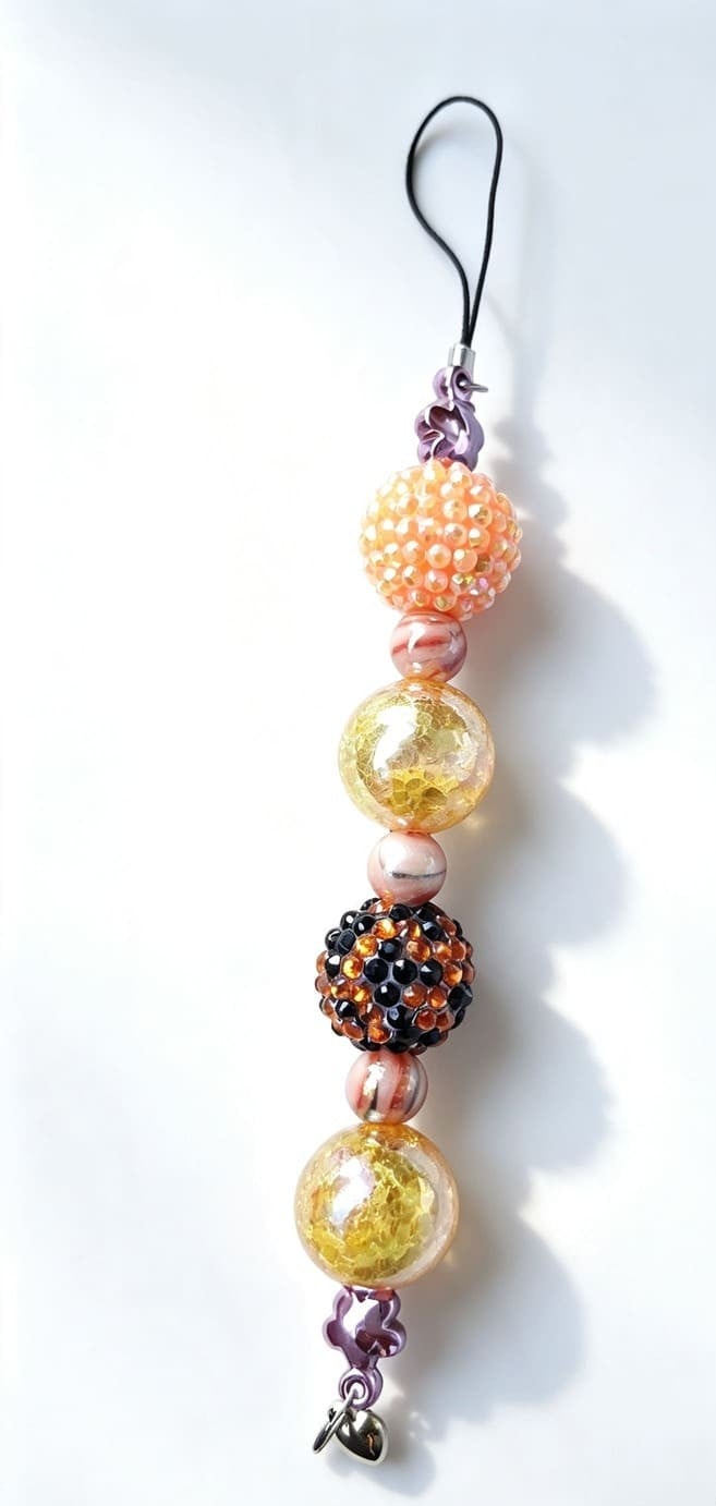 Handmade orange and gold phone charm with rhinestone beads, gold foil beads, peach accents and cord loop