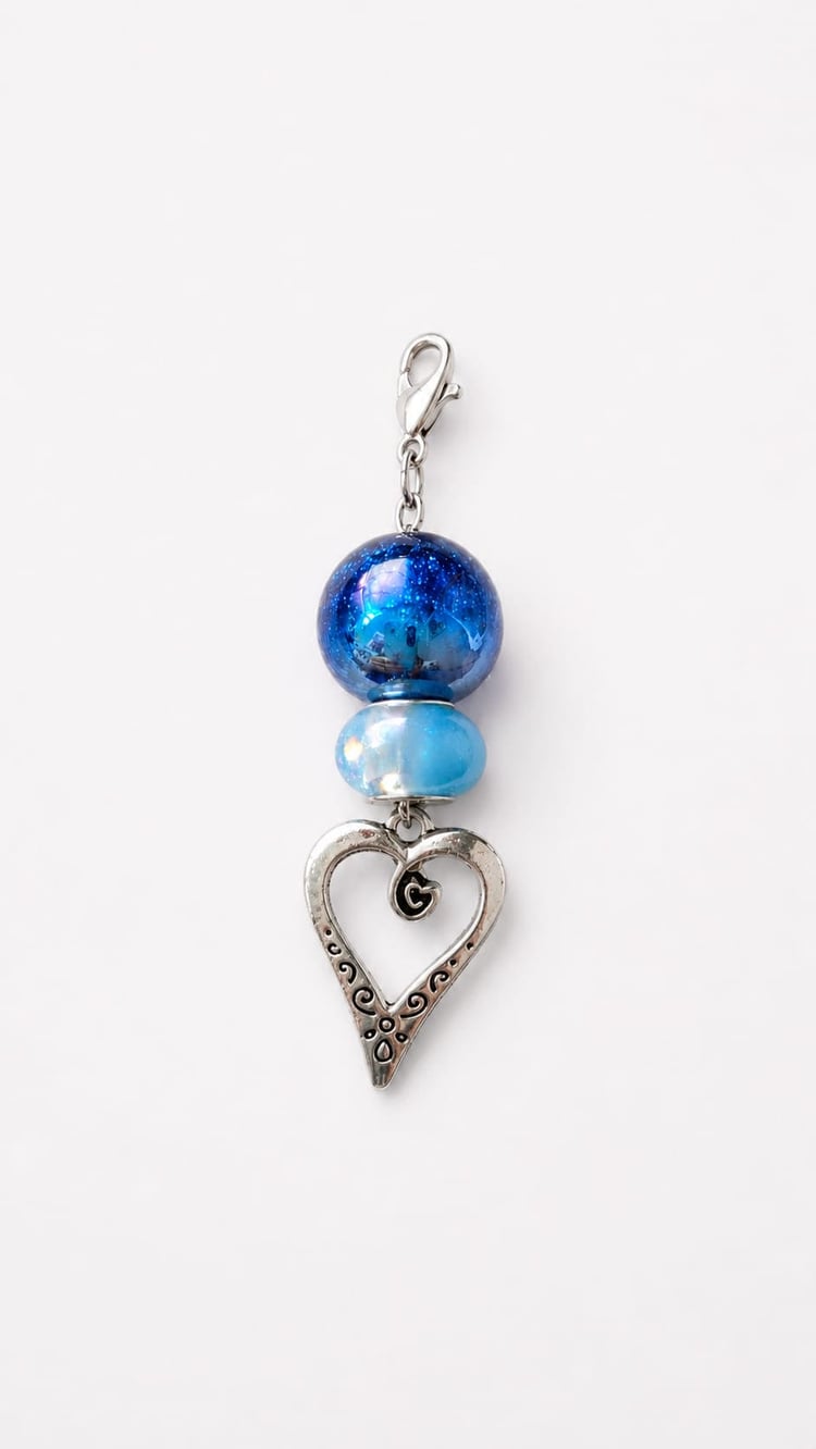 Handmade Something Blue wedding charm featuring a sparkly sapphire galaxy glitter focal bead, an ice blue iridescent accent bead, and a filigree silver heart charm.