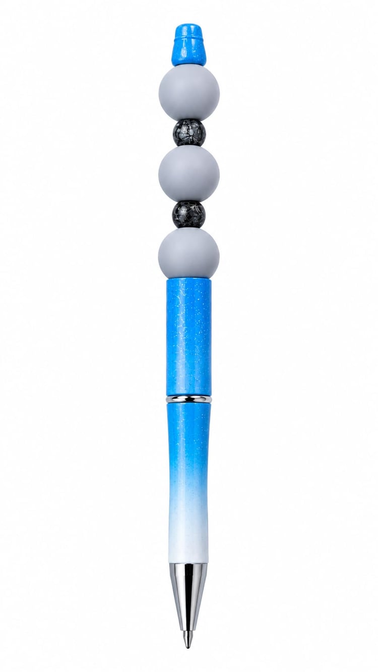 A close-up view of a custom ballpoint pen with a glittering blue-to-white ombre barrel finish, decorated with a silver tip, three smooth matte grey silicone beads, black textured crackle spacers, and a blue top cap.