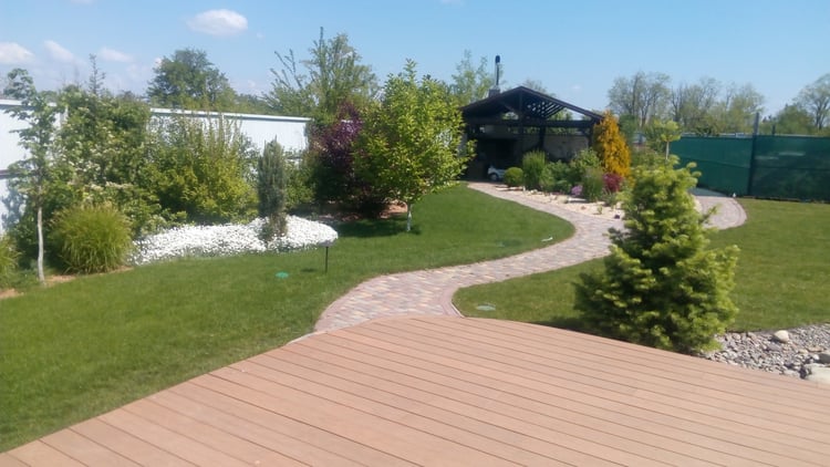 Established family garden with mature lawn, ornamental planting, curved paths and gazebo after the landscape developed.