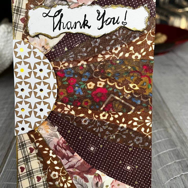 An abstract fabric card. The artwork is made to look like a multi-coloured sunflower.