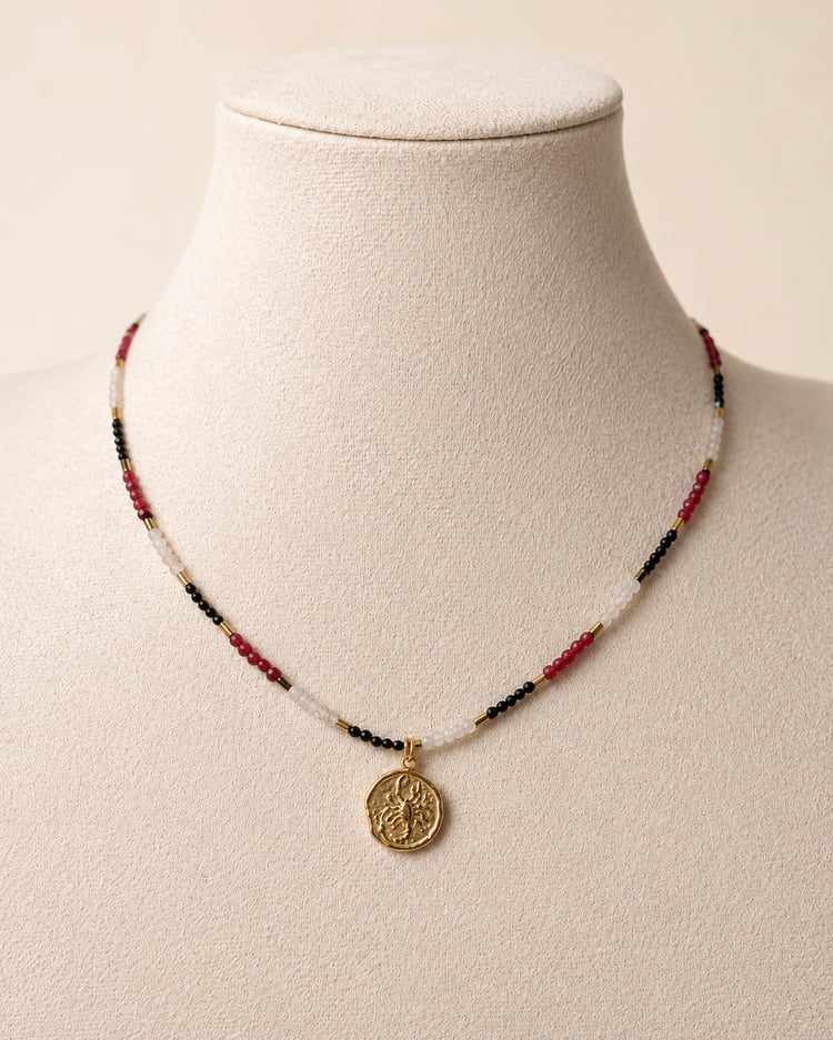 Collana Scorpione in pietre naturali con pendente dorato esposta su manichino.