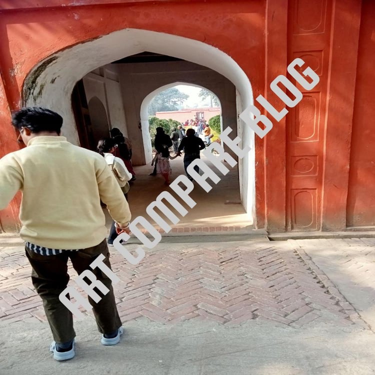 Visitors Walking Through a Weathered Red and White Double-Arched Mughal Gateway Towards a Sunlit Garden Courtyard with Herringbone Brick Paving