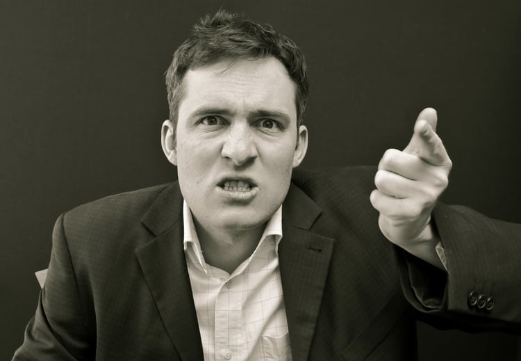 stock image of a man in a casual suit, sneering and pointing his finger