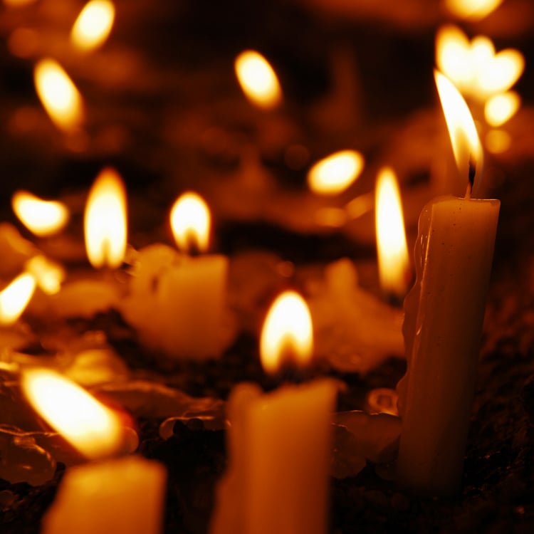 stock photo of several lit taper candles burning at different states, suggesting on-going ritual work
