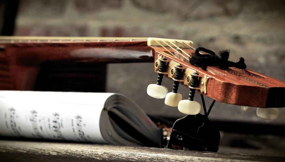 classical guitar with sheet music book