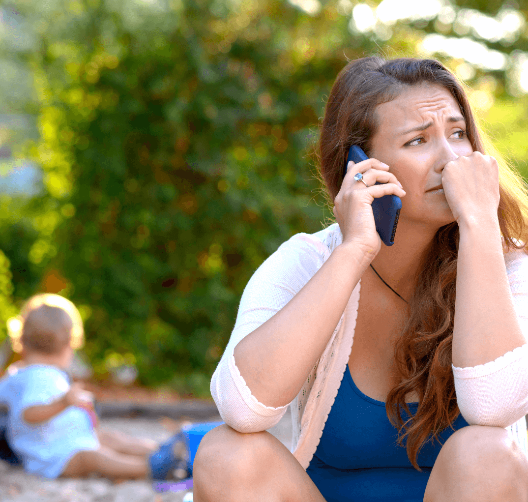 A mother, visibly stressed and juggling parenting responsibilities while experiencing anxiety. She holds a child while multitasking, depicting the challenges faced by mothers dealing with anxiety.