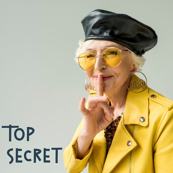 An older White woman holds a finger to her lips. Text reads: top secret.