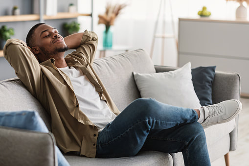 man with feet up relaxing on a white couch