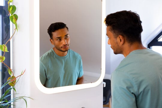 MAN LOOKING AT HIMSELF IN MIRROR