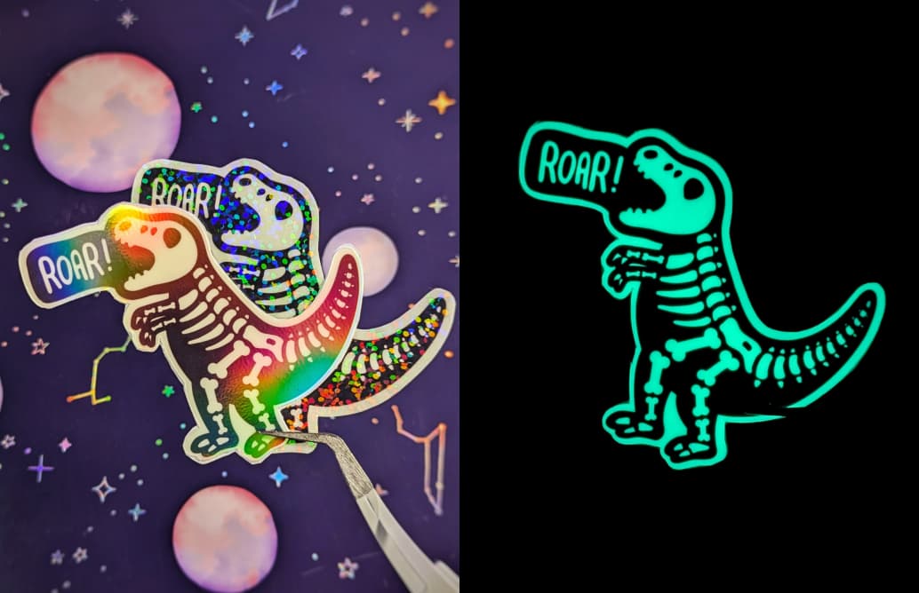 The sticker features a playful, skeleton version of a T-Rex dinosaur. The dinosaur has small, comically short arms and is positioned as if roaring, with the word ROAR! in a speech bubble above its head. The sticker glows in the dark, providing a soft, glo