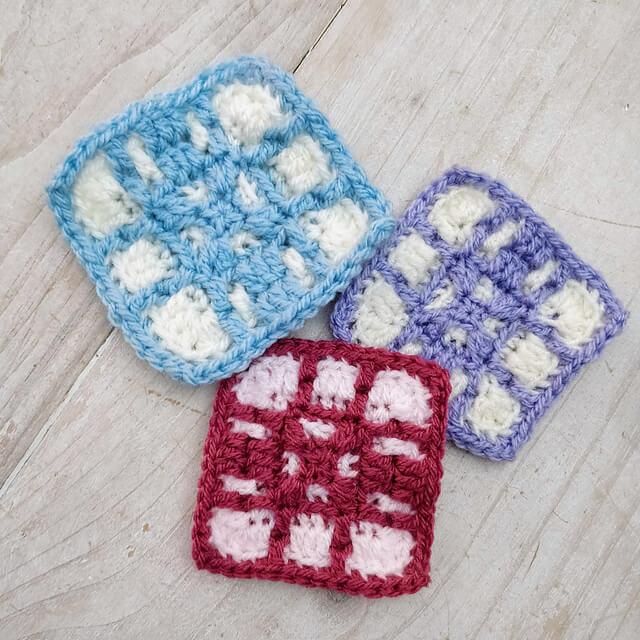 Three different coloured crocheted squares